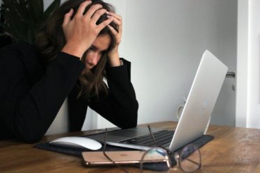 a woman sitting in front of a laptop computer