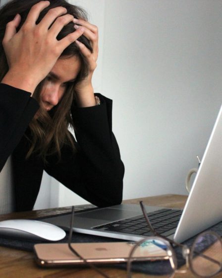 a woman sitting in front of a laptop computer